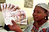 A woman displays several 10,000 CFA (African Financial Community) franc banknotes in Abidjan, on April 10, 1999.
Photo by Issouf Sanogo/AFP via Getty Images