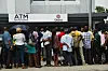 Dozens of Nigerians in a queue outside the bank.