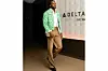 Precious Achiuwa wears a green crop jacket over beige slacks and jet-black shoes.