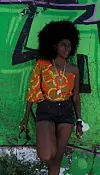 An image of Susette Adjoa standing with her leg up against a wall.