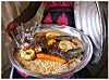 Woman serving Thieboudienne with fish, carrot and aubergine.