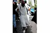 Davido wears a white tank top, a cream net top, white fur shorts, a white decorated blazer, white sneakers,
