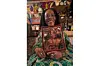 Yeye Taiwo Lijadu smiling as she holds a framed photo of Kehinde Lijadu, who is also smiling.