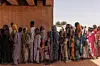 Newly arrived refugees fleeing fighting in Darfur have their documents processed in the shade of a partially finished bridge at the border of Sudan and Chad on April 20, 2024 in Adre, Chad.