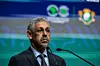 Mauritania's Sidi Ould Tah stands at a podium in front of a green and blue backdrop, wearing a dark suit and patterned tie.