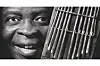 Francis Bebey poses with a mbira instrument