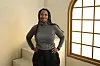 Zamo Mkhwanazi, director of ‘Laundry,’ poses for a photo wearing a dark gray turtleneck sweatshirt and black pants, smiling with arms on her hips