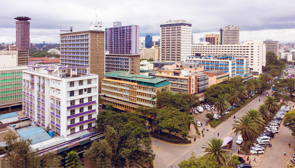 A view of Nairobi’s city center, with the Kenyatta International Convention Centre (KICC) visible in the background (far left). The KICC will host the inaugural Pan-African Architecture Biennale in 2026. Aerial view of Nairobi city center showing high-rise buildings, palm-lined streets, and the Kenyatta International Convention Centre tower in the background (far left), which will host the first Pan-African Architecture Biennale in 2026.