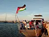 Volunteers aboard a Gaza-bound boat flying the Palestinian flag.