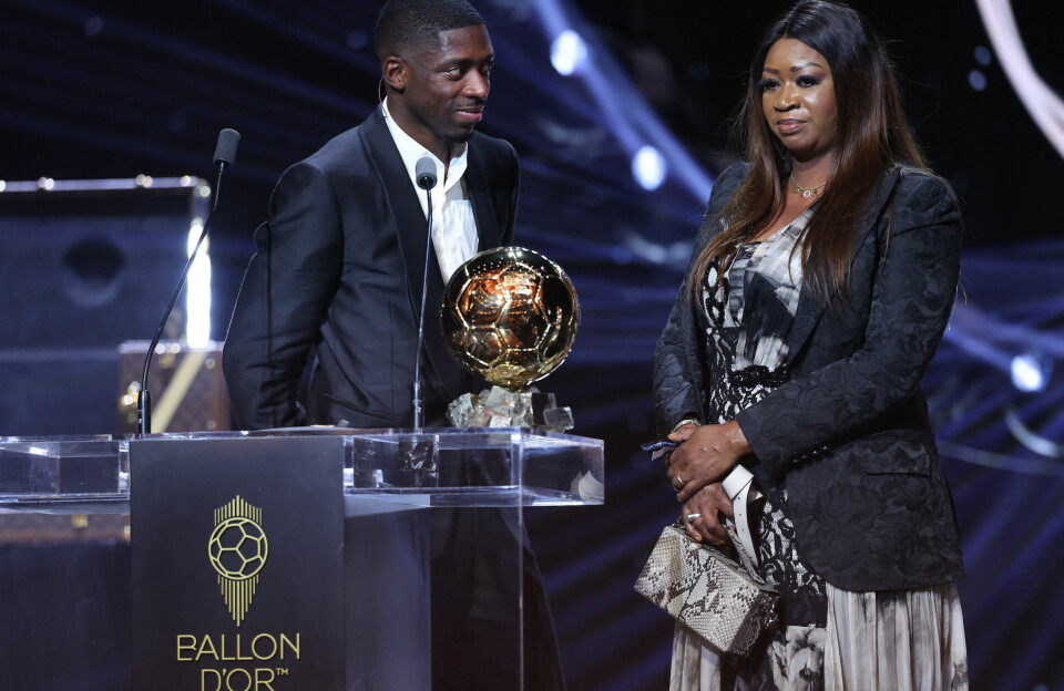 Paris Saint-Germain's French forward Ousmane Dembélé stands on stage next to his mother after receiving the Ballon d'Or award during the 2025 Ballon d'Or France Football award ceremony at the Theatre du Chatelet in Paris on September 22, 2025. Ousmane Dembélé stands on stage next to his mother, smiling at her, with the Ballon d’Or in front of them on a podium