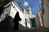 A Libyan woman walks past a mosque in one of the alleys of Tripoli's Old City