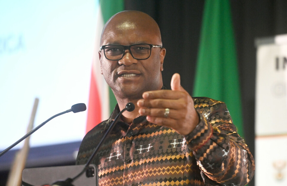 South Africa’s ambassador to France, who passed away today by apparent suicide. The late Nathi Mthethwa gestures with one hand as he speaks into a microphone on a podium.