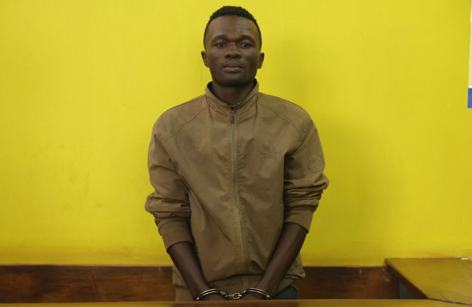 Kenyan police have offered a reward for information leading to the arrest of Collins Jumaisi Khalusha, the man they say confessed to murdering and dismembering 42 women. Collins Jumaisi Khalusha stands in the dock in a court in Kenya, with a yellow wall behind him.
