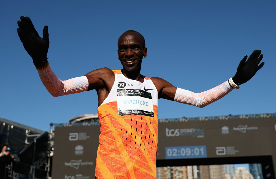 Celebrated Kenyan runner Eliud Kipchoge wants to add a New York City Marathon medal to his impressivr collection. Kenyan runner Eliud Kipchoge waves to fans and smiles, wearing an orange and white vest.