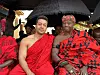 Singer Joe Jacquest is pictured in a red traditional Ghanaian attire next to a chief.