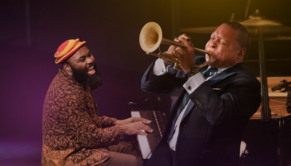 This Friday and Saturday, October 24 and 25, 2025, Makhathini will be joined on stage by trumpeter, composer, and artistic director of Jazz at Lincoln Center, Wynton Marsalis. Nduduzo Makhathini sits at a piano, laughing as he watches Wynton Marsalis playing the trumpet.