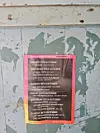 Poster with the 2025 NBO Film Festival screening schedule taped to a door. The schedule lists free screenings at Kaloleni Social Hall.