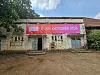 Front view of Kaloleni Social Hall, an old stone building with weathered walls and blue wooden doors. A large red and pink NBO Film Festival banner runs above the entrance