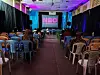 Audience seated in colorful plastic chairs inside Kaloleni Social Hall, facing a screen with the NBO Film Festival logo.