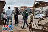 People talking on a street in Harare, Zimbabwe, next to signs advertising USD transactions.