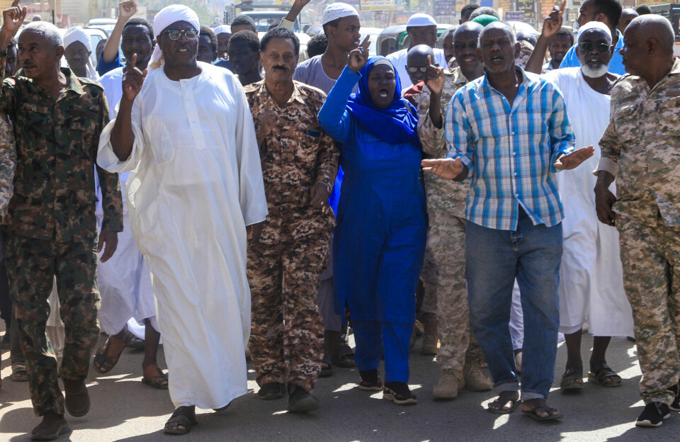 Residents take part in a demonstration in Omdurman today, October 31, to protest against the Rapid Support Forces' reported 'atrocities' in El Fasher in western Sudan. A group of people, some in military fatigues, protest in the street, gesturing with their hands as they appear to be shouting.
