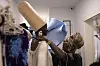 Creative director Bubu Ogisi (R) arranges a model's outfit ahead of a private presentation and performance to view the SS26 collection during Lagos Fashion Week in Lagos, on October 31, 2025.