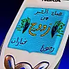 Drawing of an old Nokia phone; its display shows the mixtape title in Arabic, reading “Good morning from Zouj.”