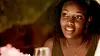 A close-up of actress Mumbi Maina smiling warmly during a candlelit dinner scene in Nafsi.