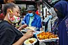 Somali American community members, wearing COVID-era masks, serve a home-made lunch in Minneapolis, Minnesota.