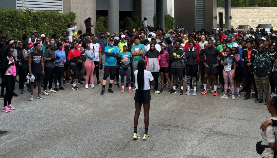 Emily Chepkor addresses the We Run Nairobi community before a Saturday morning run. Emily Chepkor stands in front of a large crowd of runners outside a building, preparing to lead a run.
