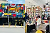 Two side-by-side images of Soma Nami Books in Ngara. One shows the outside of the store with a bold, colorful mural and balloon decorations. The other shows people browsing books inside a well-lit space with tall shelves full of books.