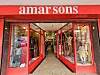 The entrance of Amar Sons store with bright red framing and mannequins dressed in colorful traditional Indian garments displayed in glass windows.
