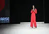 An image of Naomi Campbell with a microphone in her hand, talking to the audience at Arise Fashion Week in 2019.