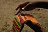 A man holding a piece of Kente cloth fabric.