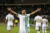 Houssem Eddine Aouar of Algeria celebrates after scoring a goal, with his arms up to the side. Other Algerian players can be seen in the background, facing the other way.