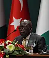 Nigerian President Bola Ahmed Tinubu sits in front of a microphone during a press conference in Turkey.