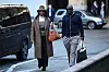 Nigeria's former oil minister, who is also the former president of OPEC, Diezani Alison-Madueke, walks on the street with a man on her side. She wears a hat and a long coat.