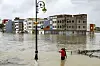 Youths stand along an inundated street in Morocco's northwestern city of Ksar el-Kebir on January 29, 2026, as several neighborhoods flooded in the city due to a rise in the water level of the Loukkos river following recent heavy rainfall.