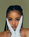 Tyra Chantey in a close-up portrait, serving soft glam with braided hair, jeweled accents, and white gloves.