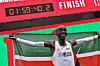 Kenya's Eliud Kipchoge celebrates, smiling and holding the Kenyan flag, after busting the mythical two-hour barrier for the marathon on October 12, 2019, in Vienna.