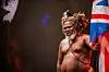 South African Artist Mbuso Khoza wearing traditional Zulu attire, holding a British Flag.