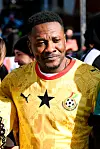 Asamoah wears the new Ghana national football team jersey and looks off to his left, a slight smile on his face.