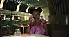 A still from Call Of My Life showing actress Uzoamaka Power in pigtails and a pink overalls while on a phone call.