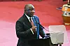 South African President Cyril Ramaphosa speaking at a podium, gesturing with his hand.