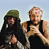 Dua Saleh is wearing a green hat and braids, next to Bon Iver, who is wearing a beige bandana with a red floral print.