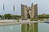 Independence monument in Lomé, Togo, beside a reflecting pool and flagpoles.