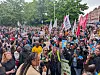 Large crowd of protesters gathered outside Leinster House in Dublin with banners and flags.