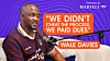 Wale Davies is seated at a microphone in front of a purple backdrop featuring a quote graphic.