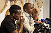 Kenyan journalist and human rights activist Boniface Mwangi (R) speaking at a press conference with multiple microphones in front of him, while Ugandan activist Agather Atuhaire (L), eyes closed, comforts him.