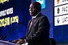 Cyril Ramaphosa speaks at a podium beside election results graphics at the IEC National Results Center in Johannesburg.